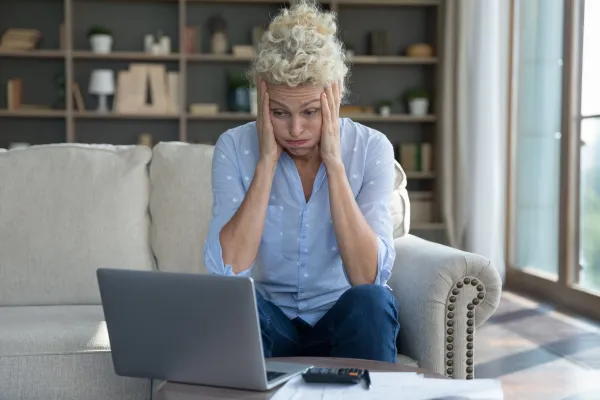 confused and frustrated older woman looking at a computer screen