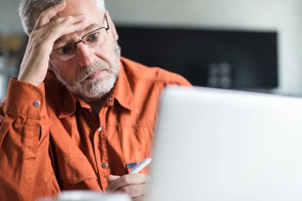 man who is worried looking at a computer