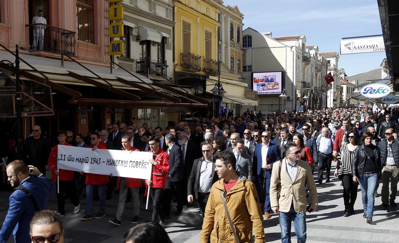 People take part in the International March of the Living, through downtown Bitola, southern Macedonia, commemorating the victims of the Holocaust, on Sunday, March 11, 2018. Thousands of people have joined a march in southern Macedonian town of Bitola, commemorating 75 years of deportation and destruction of almost entire country's Jewish community in the Nazi extermination camp Treblinka, during World War II. The banner left reads in Macedonian "11 of March 1943 - Never Again". (AP Photo/Boris Grdanoski)