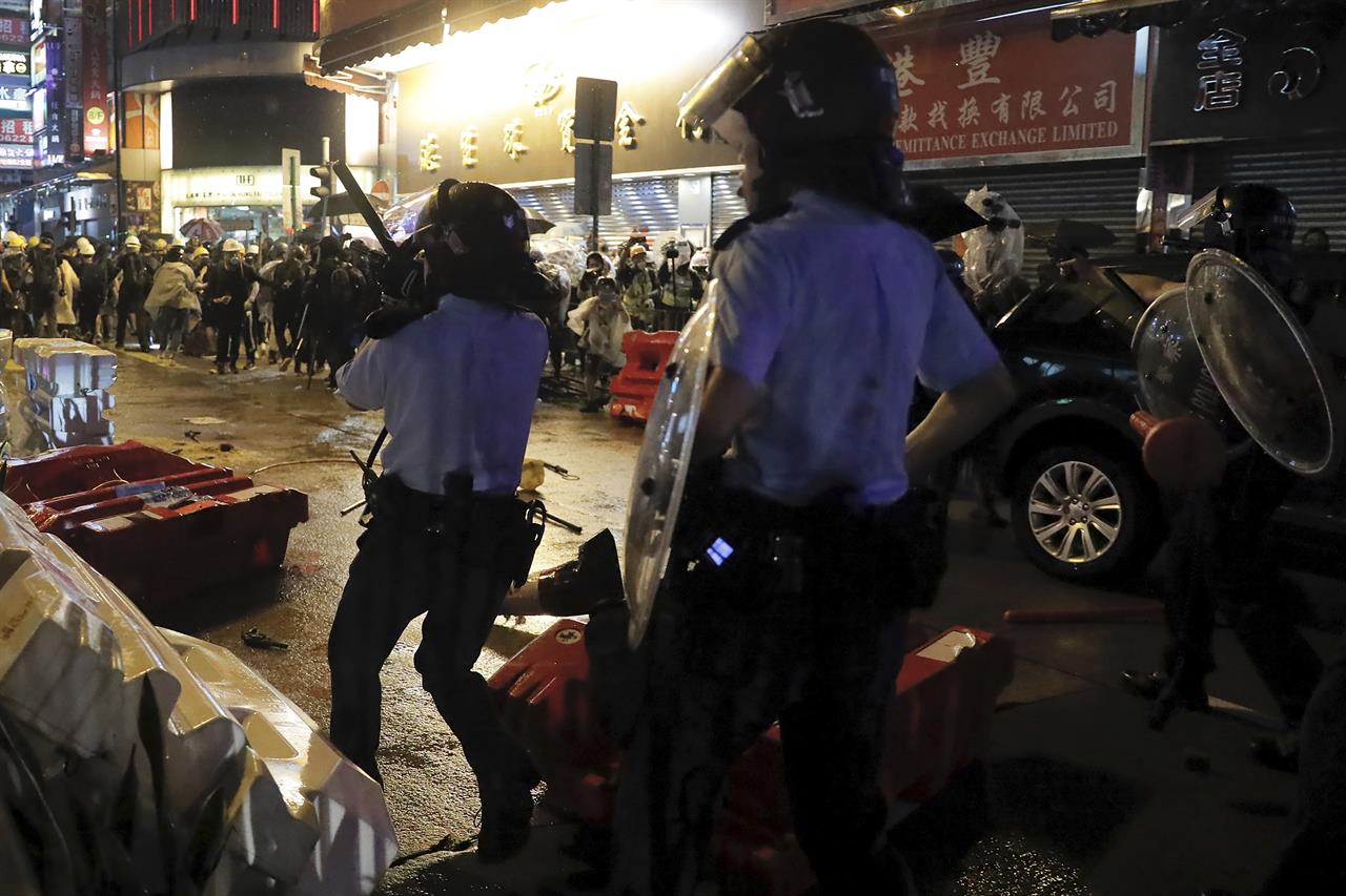 A policeman's gun was dropped on the floor, left, after clashed with demonstrators on a street during a protest in Hong Kong on Sunday, Aug. 25, 2019. Lawmakers on each side of Hong Kong's political divide say the other side bears responsibility after violence during anti-government protests over the weekend. (AP Photo/Kin Cheung)
Police defend warning shot as Hong Kong divide widens