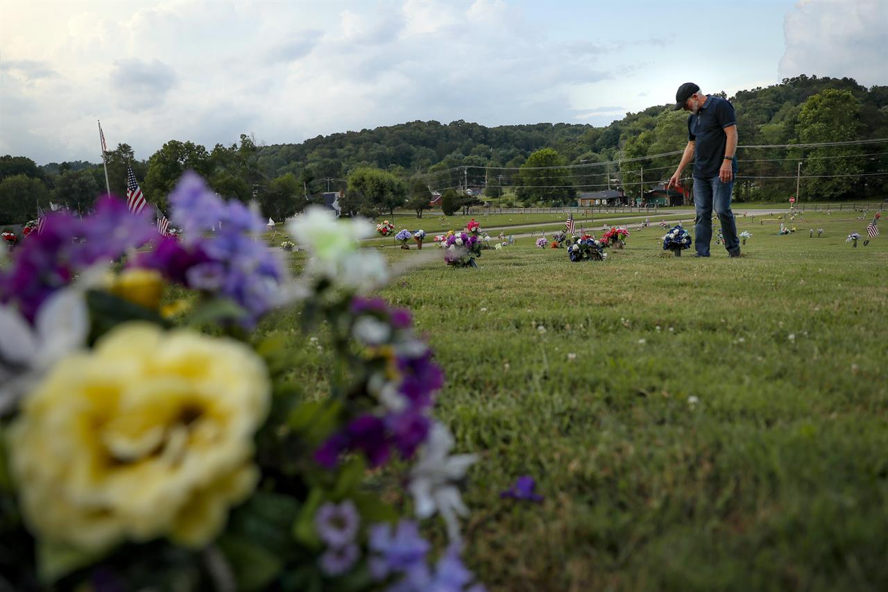 FILE - In this July 17, 2019 file photo, Eddie Davis steps up to the gravestone of his son Jeremy, who died from the abuse of opioids in Coalton, Ohio. While the nation's attorneys general debate a legal settlement with Purdue Pharma, the opioid epidemic associated with the company's blockbuster painkiller OxyContin rages on. The drugs still kill tens of thousands of people each year with no end in sight. (AP Photo/John Minchillo, File)
'Once you have it, you need it': Opioid epidemic still rages