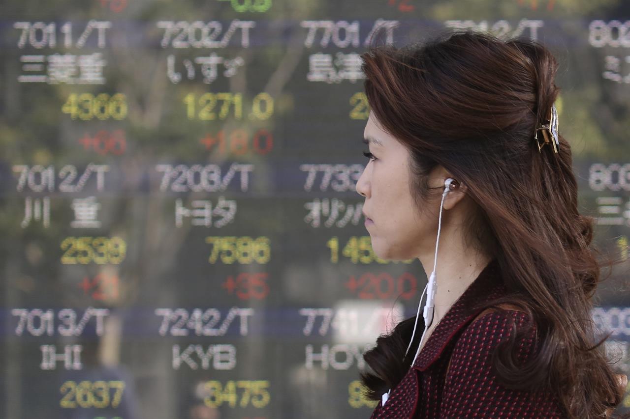 A woman walks by an electronic stock board of a securities firm in Tokyo, Tuesday, Nov. 5, 2019. Asian shares have advanced after the Dow Jones Industrial Average returned to a record high. Benchmarks rose across the region, led by a 2% jump in Japan’s Nikkei 225 index. (AP Photo/Koji Sasahara)
World shares rise on hopes for easing in US-China tensions