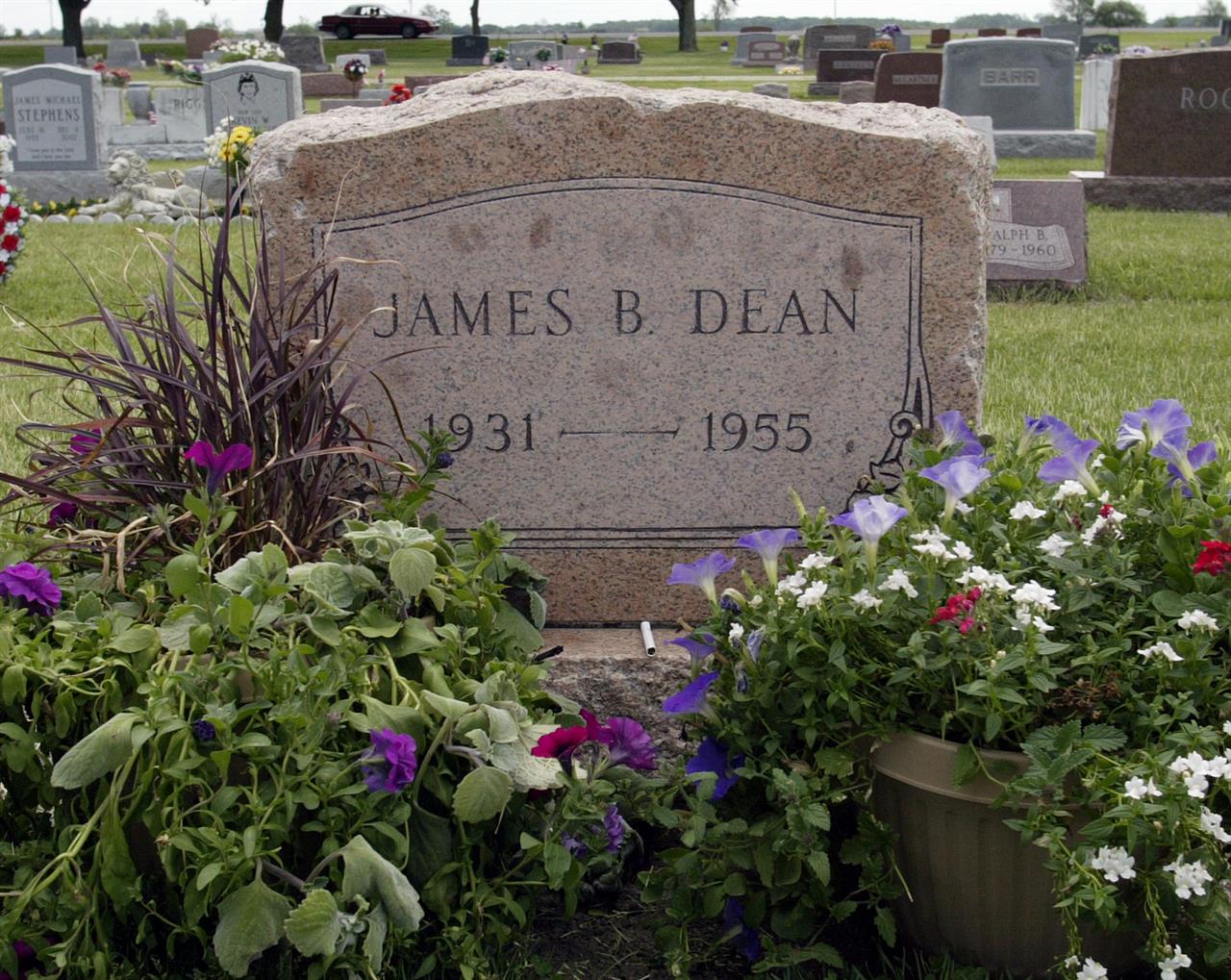 FILE - This May 27, 2005 file photo shows plants and flowers at the grave of actor James Dean in Fairmount, Ind. Dean hasn’t been alive in 64 years, but the “Rebel Without a Cause” actor has been cast in a new film about the Vietnam War. The filmmakers behind the independent film “Finding Jack” said Wednesday that a computer-generated Dean will play a co-starring role in the upcoming production. The digital Dean is to be assembled through old footage and photos and voiced by another actor. (AP Photo/John Harrell, File)
