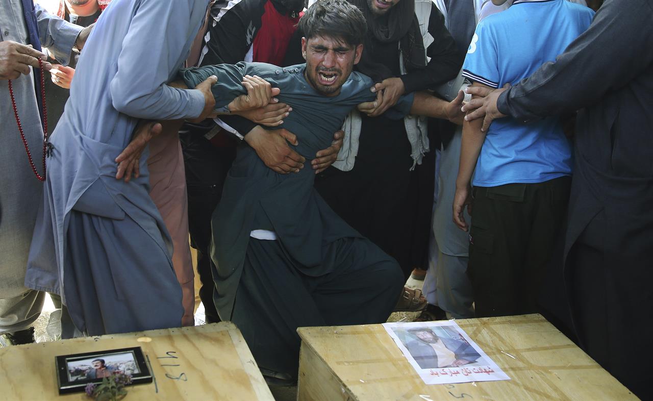 FILE - In this Aug. 18, 2019 file photo, men hold back a grieving relative next to the coffins of victims of a wedding hall bombing during a mass funeral in Kabul, Afghanistan. A new survey released by the Asia Foundation Tuesday, Dec. 3, 2019, says Afghans are increasingly fearful for their personal safety, but slightly more believe their war-weary country is moving in the right direction compared to previous years. (AP Photo/Rafiq Maqbool, File)
Survey: Afghans’ fear for personal safety has increased