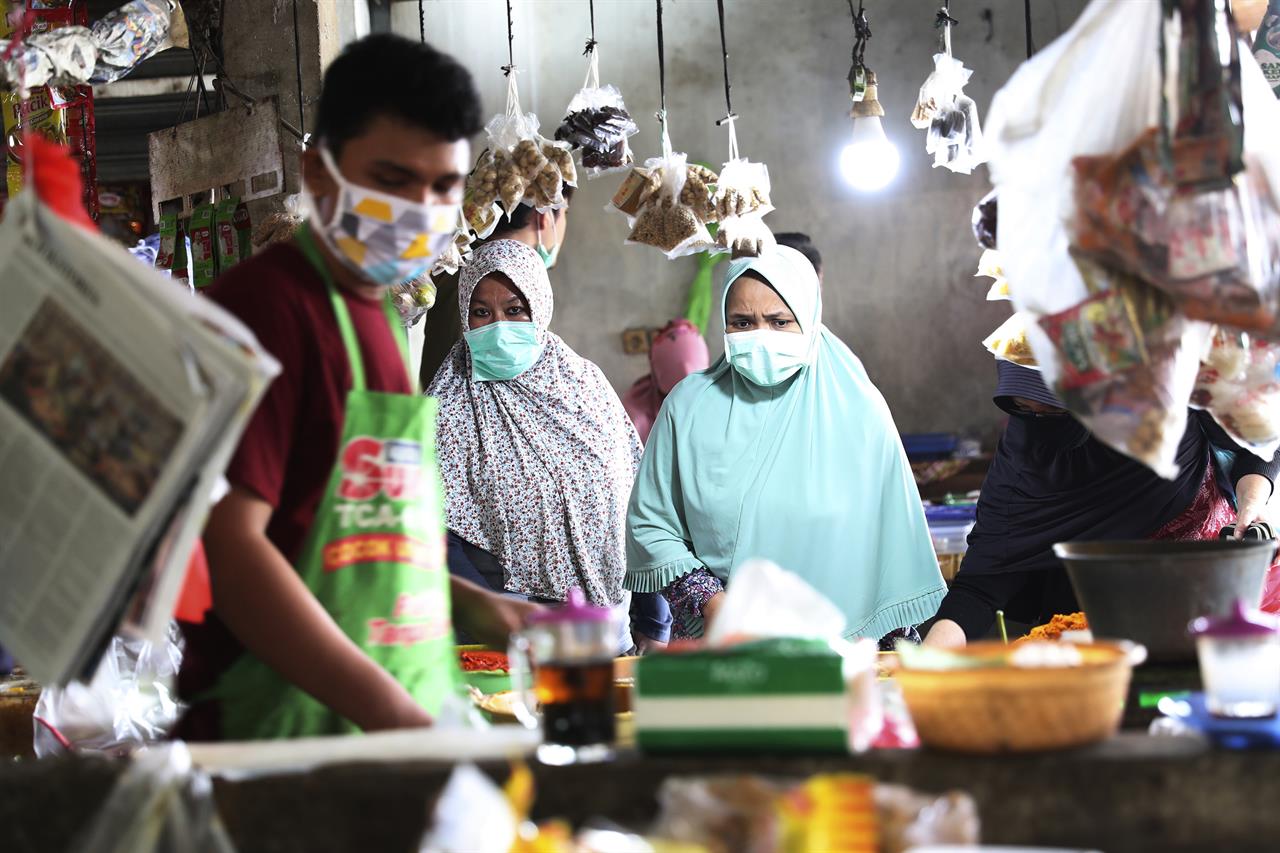 People wear masks at a traditional market in Jakarta, Indonesia, Friday, April 10, 2020. Authorities began stricter measures to halt the new coronavirus' spread in Indonesia's capital Friday, with its normally congested streets empty after death toll spiked in the past week. (AP Photo/Achmad Ibrahim)
Mosques, streets quiet as Indonesia's capital tightens rules