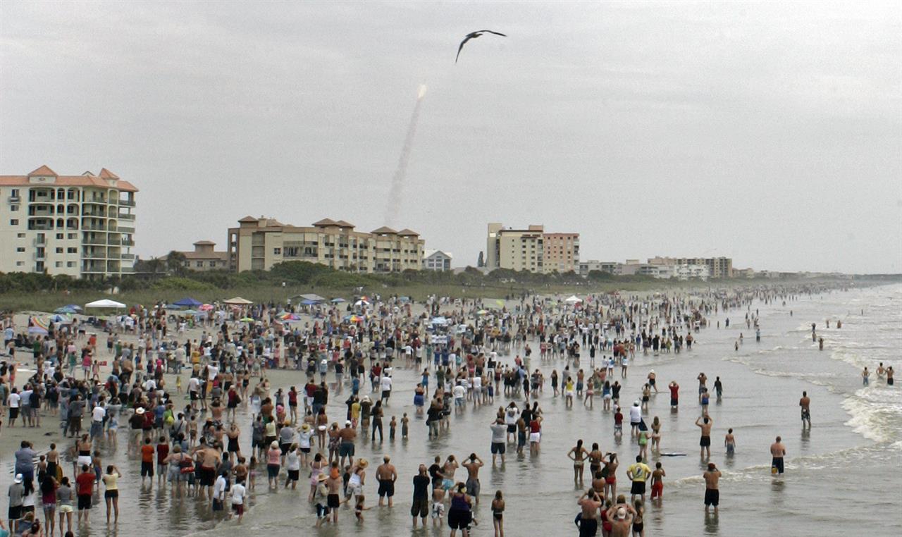 FILE - In this Friday, July 8, 2011 file photo, crowds gather in the surf and on the beach in Cocoa Beach, Fla., to watch the launch of the space shuttle Atlantis on STS-135. This is the final U.S. shuttle mission before the fleet is retired. In ordinary times, the beaches and roads along Florida’s Space Coast would be packed with hundreds of thousands of spectators, eager to witness the first astronaut launch from Florida in nine years, scheduled for May 27, 2020. In the age of coronavirus, local officials and NASA are split on whether that's a good idea. (AP Photo/Dave Martin)
Will virus keep Florida spectators from astronaut launch?