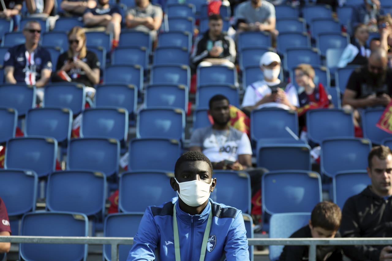 A ball carrier wears a face mask prior to the friendly soccer match between Paris Saint Germain and Le Havre, in Le Havre, western France, Sunday, July 12, 2020. For the first time since the coronavirus shut down sports and chased away spectators, Neymar, Kylian Mbappe and other soccer stars are going to play again in front of fans. (AP Photo/Thibault Camus)
The Latest: Florida AD says he had a bout with coronavirus