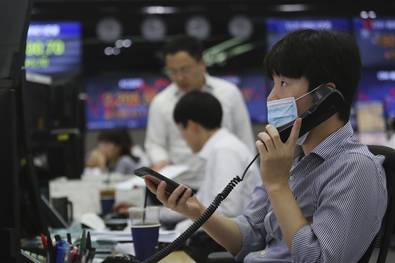 A currency trader watches monitors at the foreign exchange dealing room of the KEB Hana Bank headquarters in Seoul, South Korea, Thursday, July 16, 2020. Shares fell back in Asia on Thursday after markets worldwide rallied on rising hopes for a COVID-19 vaccine. (AP Photo/Ahn Young-joon)
Asian stock prices rebound after Wall Street slips