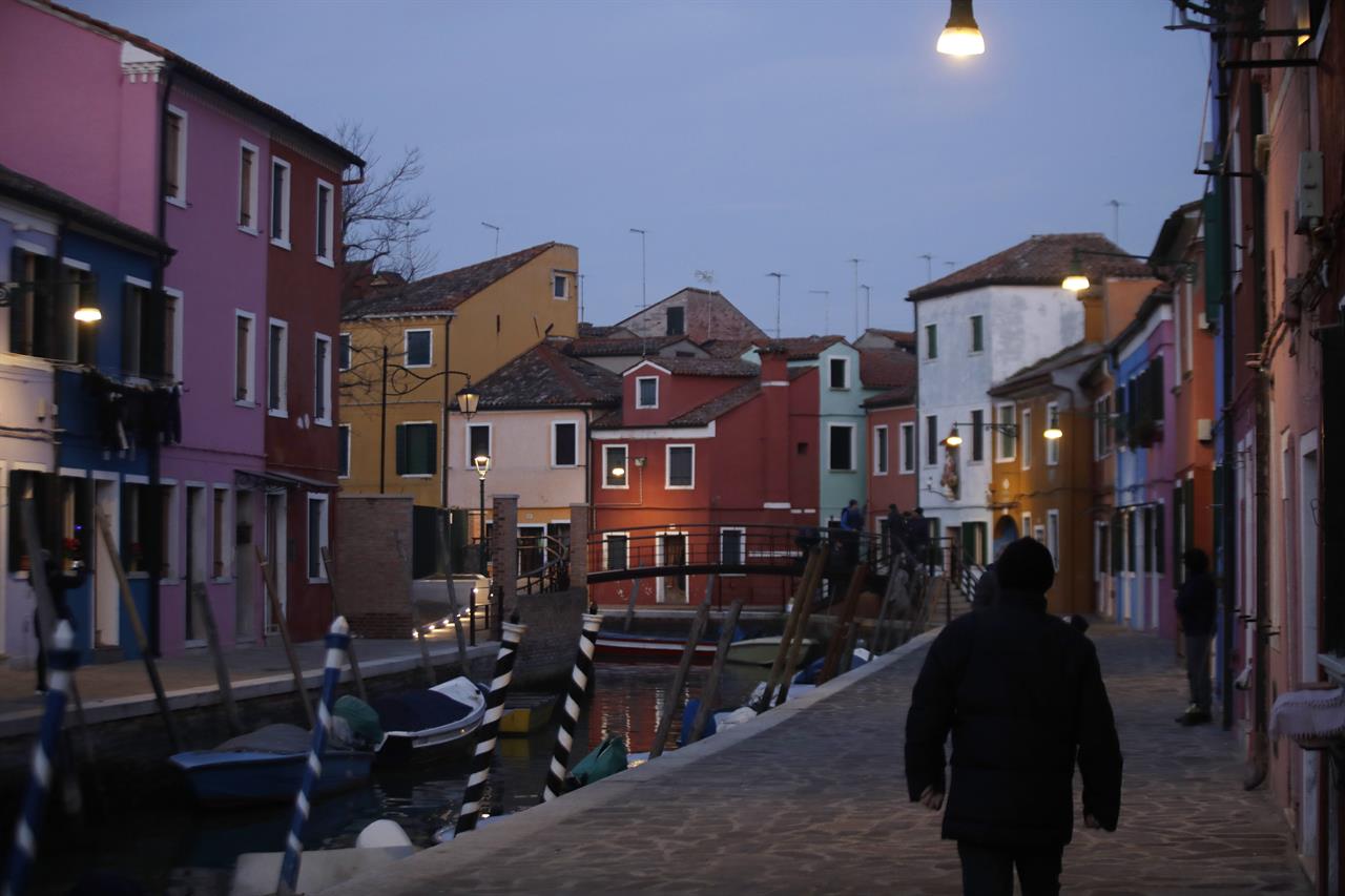In this image taken on Thursday, Jan. 16, 2020, people walk at the Burano island, Italy. The Venetian island of Burano's legacy as a fishing village remains the source of its charms: the small colorful fishermen's cottages, traditional butter cookies that were the fishermen's sustenance at sea and delicate lace still stitched by women in their homes. As the island's population dwindles, echoing that of Venice itself, so too are the numbers of skilled artisans and tradespeople who have kept the traditions and economy alive. (AP Photo/Luca Bruno)
Venetian islands revamp traditions to counter depopulation