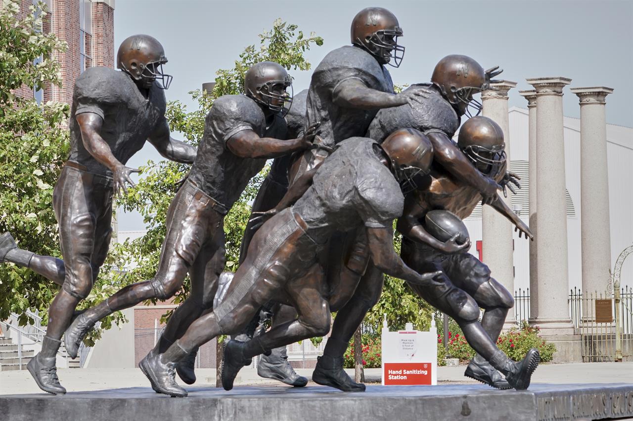 A hand sanitizing station is placed behind a statue of football players outside Memorial Stadium in Lincoln, Neb., Tuesday, Sept. 15, 2020. (AP Photo/Nati Harnik)
Reverse: Big Ten will try to play fall football after all