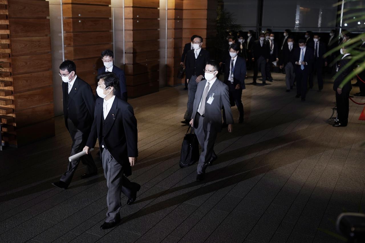 Newly appointed ministers, left, are escorted by staffs as they leave the official residence for the Imperial Palace to attend the attestation ceremony of the new cabinet by Prime Minister-elect Yoshihide Suga, Wednesday, Sept. 16, 2020, in Tokyo. (AP Photo/Eugene Hoshiko)
New Japanese Cabinet retains most key ministers