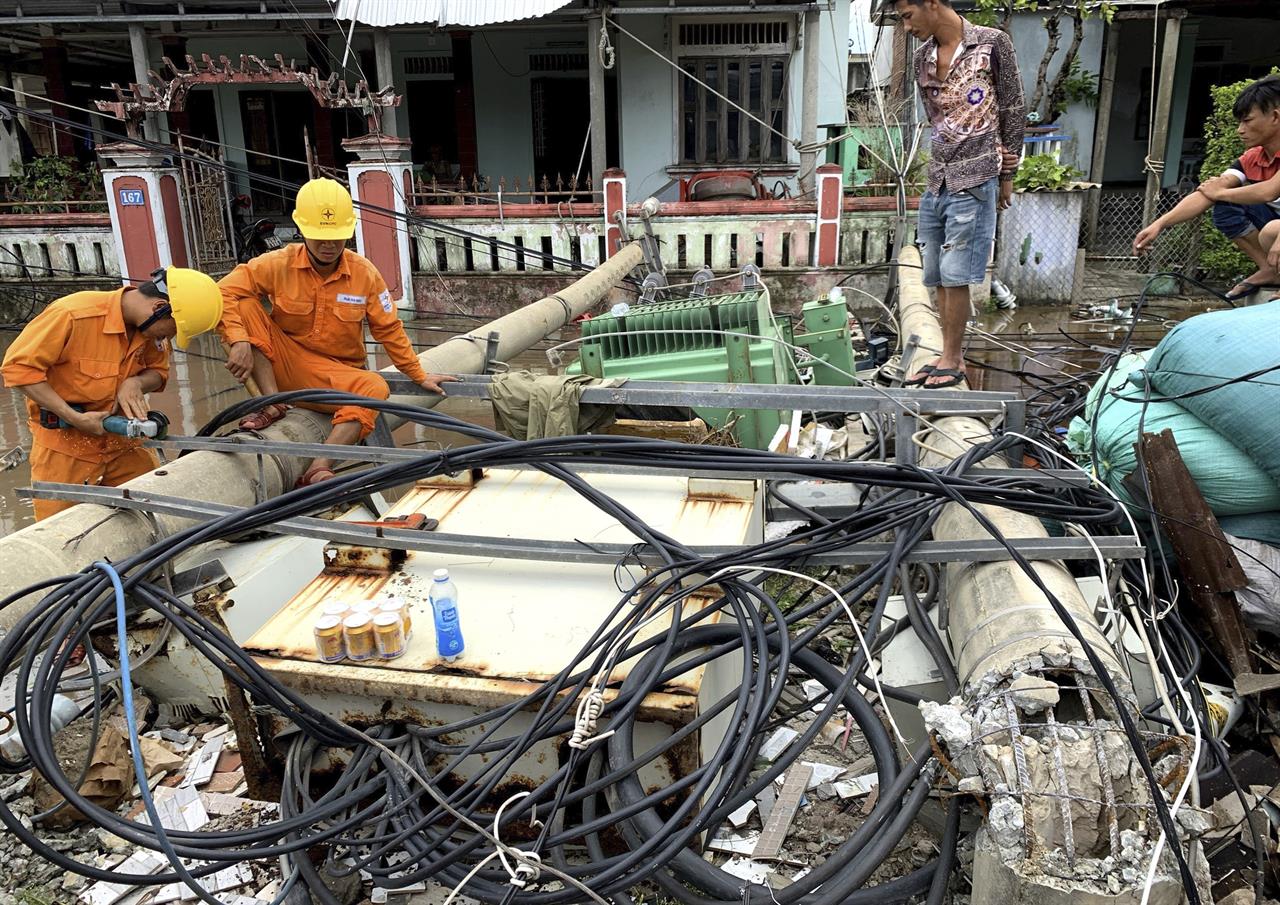 Workers clear collapsed electric poles during the landfall of Noul tropical storm in Hue, Vietnam, Friday, Sept. 18, 2020. The storm weakened to a tropical depression after making landfall in central Vietnam causing a few deaths and injuries. (VNA via AP)