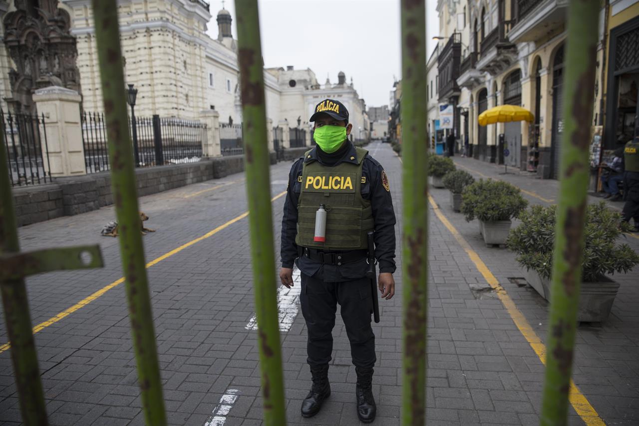 A police officer stands guard one block away from the Constitutional Court building in Lima, Peru, Thursday, Sept. 17, 2020. The court rejected a request by President Martin Vizcarra Thursday to halt impeachment proceedings being pushed by opposition lawmakers who contend he tried to cover up ties with a controversial ally. (AP Photo/Rodrigo Abd)