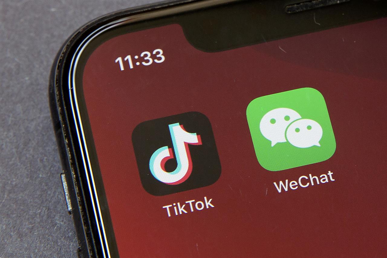FILE - Icons for the smartphone apps TikTok and WeChat are seen on a smartphone screen in Beijing, in a Friday, Aug. 7, 2020 file photo. The Commerce Department said President Trump’s proposed ban of the apps WeChat and TikTok will go into effect Sunday, Sept. 20, to “safeguard the national security of the United States.” The government said its order, previously announced by Trump in August, will “combat China’s malicious collection of American citizens’ personal data.” (AP Photo/Mark Schiefelbein, File)