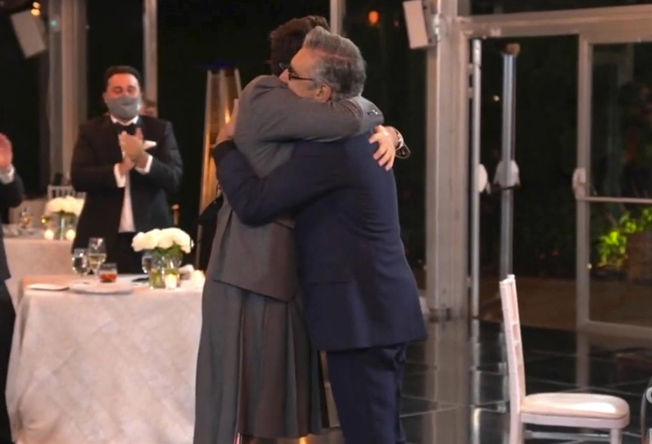 In this video grab captured on Sept. 20, 2020, courtesy of the Academy of Television Arts & Sciences and ABC Entertainment, Dan Levy, left, hugs his father Eugene Levy, winner of the award for outstanding lead actor in a comedy series for "Schitt's Creek" during the 72nd Emmy Awards broadcast. (The Television Academy and ABC Entertainment via AP)