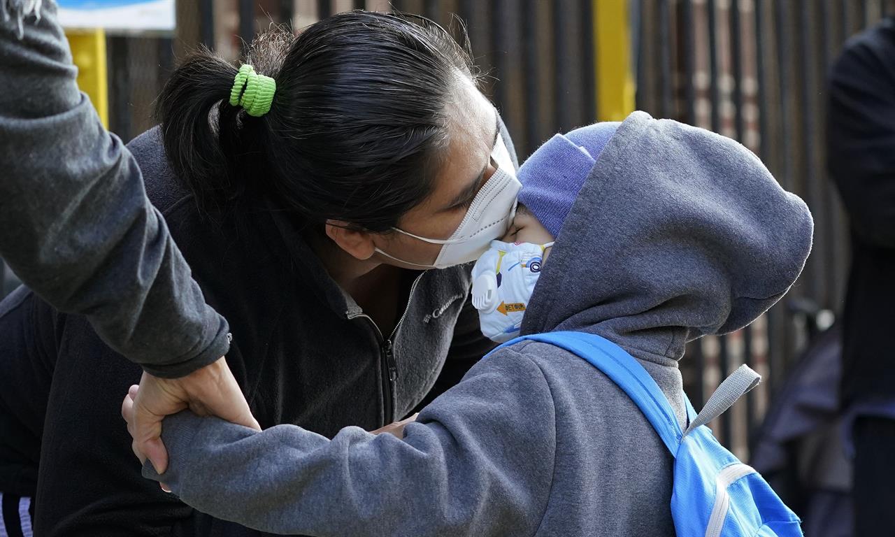 Maria Flores kisses her son Pedro Garcia, 4, while a teacher takes his hand as he arrives for the first day of school at the Mosaic Pre-K Center in Queens, Monday, Sept. 21, 2020, in New York. The city public schools delayed reopening for two weeks. (AP Photo/Mark Lennihan)
For most NYC students, back to school but not the classroom