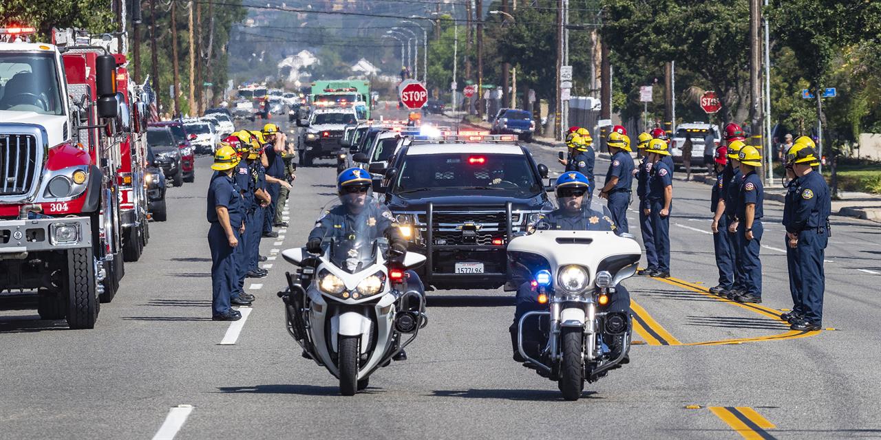 The California Highway Patrol leads the procession along with U.S. Forest Service vehicles as they escort fallen firefighter Charles Morton, killed while battling a blaze in the mountains east of Los Angeles, along Hewes Street in Orange, Calif., Tuesday, Sept. 22, 2020, from San Bernardino to the Ferrara Colonial Mortuary in Orange. Morton, 39, a San Diego native, was a 14-year veteran of the U.S. Forest Service and a squad boss for the Big Bear Interagency Hotshots in San Bernardino National Forest, officials said. (Mark Rightmire/The Orange County Register via AP)