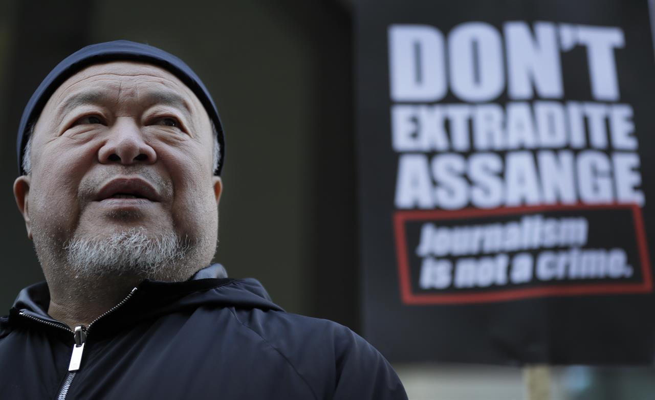 Chinese contemporary artist and activist Ai Weiwei stands with protesters outside the Old Bailey in support of Julian Assange's bid for freedom during his extradition hearing, in London, Monday, Sept. 28, 2020. (AP Photo/Kirsty Wigglesworth)
