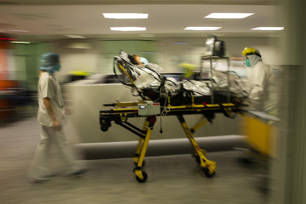 Medical staff transfer a COVID-19 patient, due to the lack of room, from the CHR Citadelle hospital in Liege, Belgium, Wednesday, Oct. 21, 2020. Authorities in Belgium fear another deadly wave of coronavirus cases could soon hit care homes for the elderly, as the country also confronts the possibility of its hospitals becoming overwhelmed with COVID-19 patients. (AP Photo/Francisco Seco)