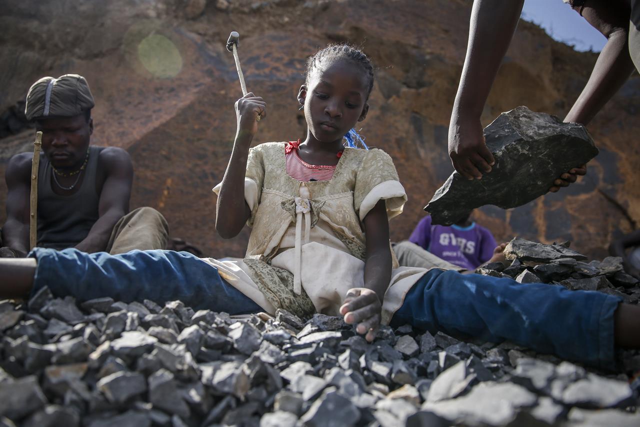 Irene Wanzila, 10, works breaking rocks with a hammer at the Kayole quarry in Nairobi, Kenya Tuesday, Sept. 29, 2020, along with her younger brother, older sister and mother, who says she was left without a choice after she lost her cleaning job at a private school when coronavirus pandemic restrictions were imposed. The United Nations says the COVID-19 pandemic risks significantly reducing gains made in the fight against child labor, putting millions of children at risk of being forced into exploitative and hazardous jobs, and school closures could exacerbate the problem. (AP Photo/Brian Inganga)