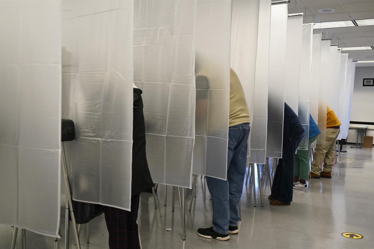 FILE - In this Oct. 6, 2020, file photo voters fill out their ballot during early voting at the Cuyahoga County Board of Elections in Cleveland. The Cybersecurity and Infrastructure Agency, which President Donald Trump signed into existence in 2018, is working with other parts of the government to safeguard an election in the middle of a pandemic. (AP Photo/Tony Dejak, File)