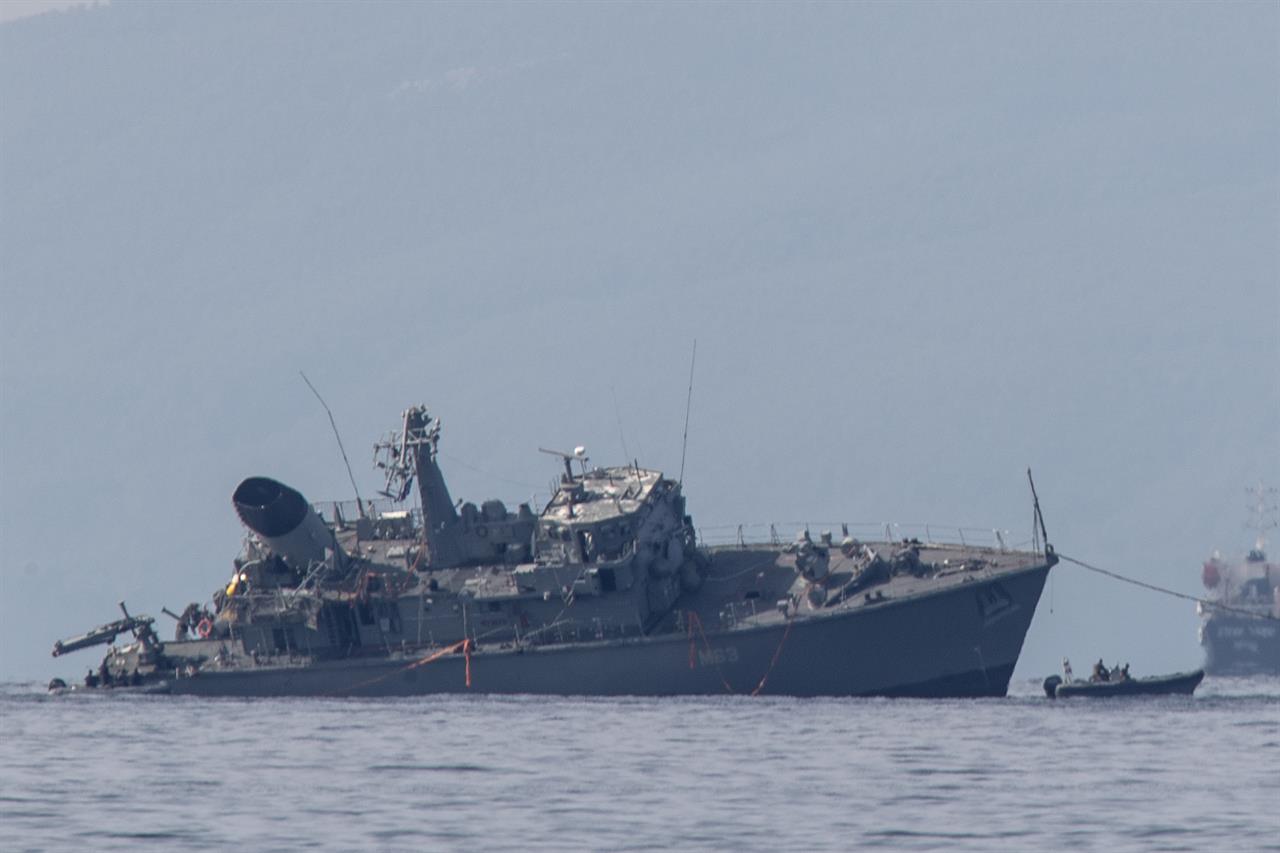 ? damaged navy minesweeper is being towed near the port of Piraeus on Tuesday, Oct. 27, 2020. Greece's coast guard says a Greek navy minesweeper and a Portuguese-flagged cargo ship have collided outside the country's main port of Piraeus, leaving two navy crew slightly injured and prompting the evacuation of the military vessel. (AP Photo/Petros Giannakouris)