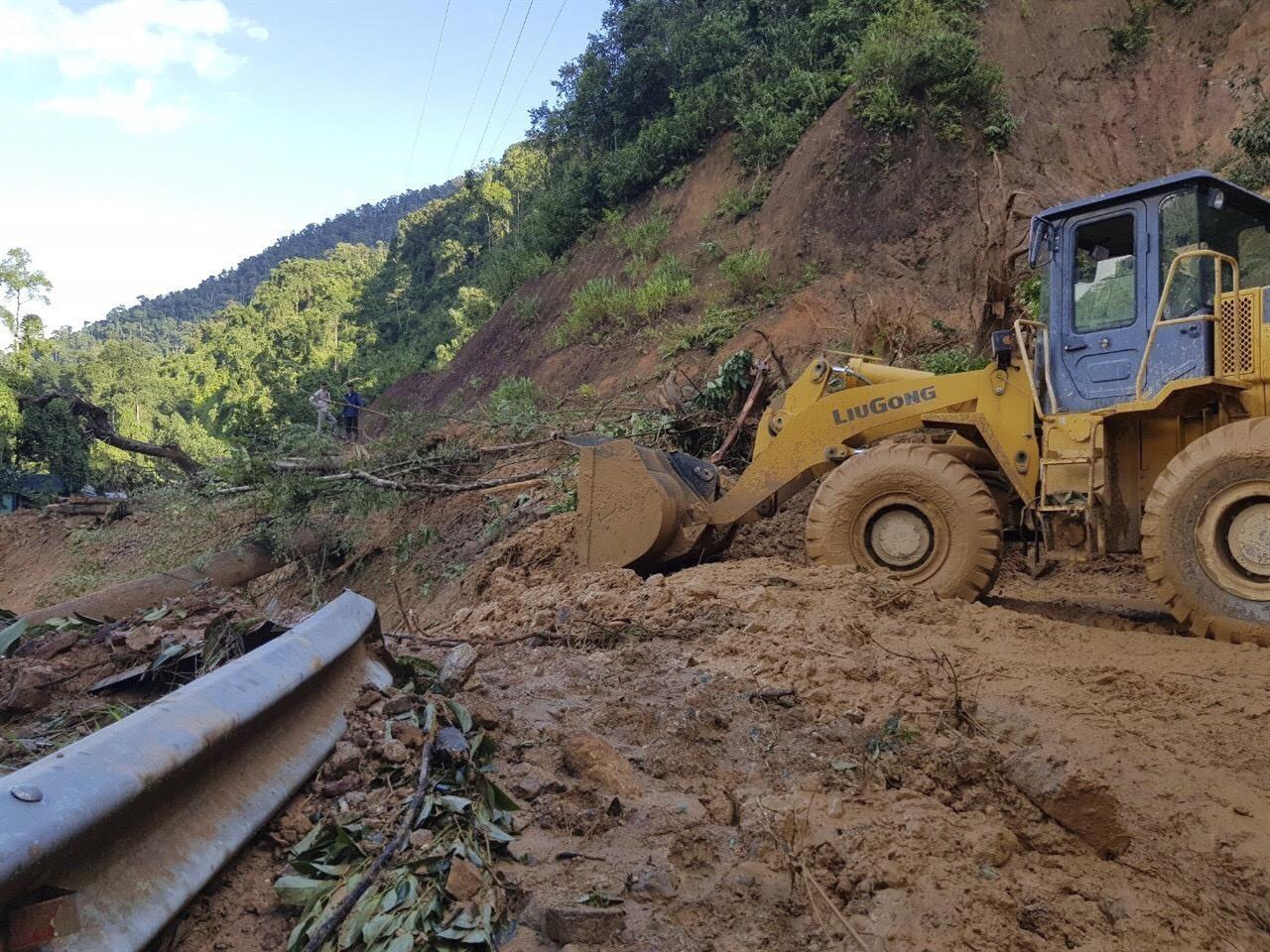 A bulldozer clears out the road damaged by landslide to access a village swamped by another landslide in Quang Nam province, Vietnam on Thursday, Oct. 29, 2020. Typhoon Molave slammed into Vietnam with destructive force Wednesday, sinking two fishing boats with 26 crew members in what was feared to be the most powerful storm to hit the country in 20 years. (Bui Van Lanh/VNA via AP)