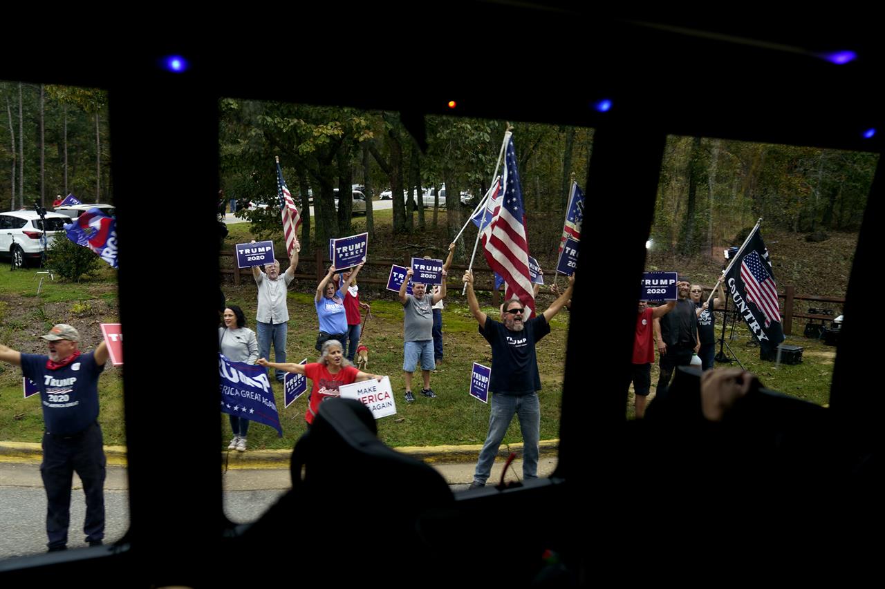 The motorcade for Democratic presidential candidate former Vice President Joe Biden drives by supporters of President Donald Trump on Tuesday, Oct. 27, 2020, in Warm Springs, Ga. (AP Photo/Andrew Harnik)