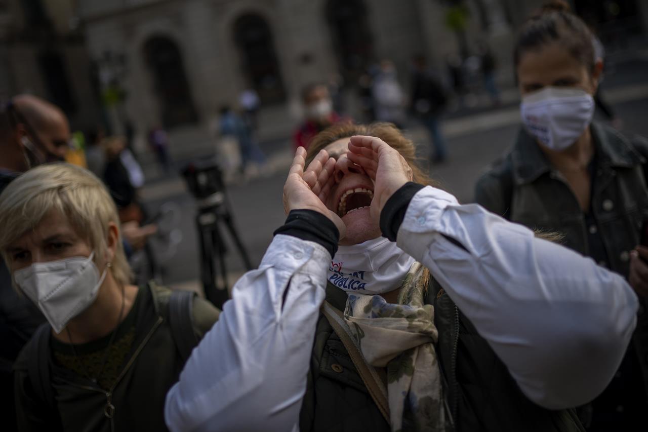 Health workers protest in front of the Palace of the Generalitat, the headquarters of the government of Catalonia, during a protest against their working conditions in Barcelona, Spain, Thursday, Oct. 29, 2020. As more of Spain's regions apply border transit restrictions, the government is seeking parliamentary approval to extend the country's newly declared state of emergency to rein in the resurging coronavirus pandemic until May, a proposal that is rejected by some opposition parties. (AP Photo/Emilio Morenatti)