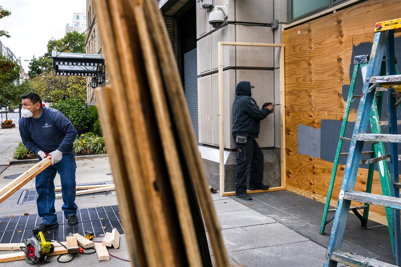 Ahead of the presidential election, workers board up Brown Bag, a restaurant on I Street NW, Friday, Oct. 30, 2020, near the White House in downtown Washington. (AP Photo/Jacquelyn Martin)