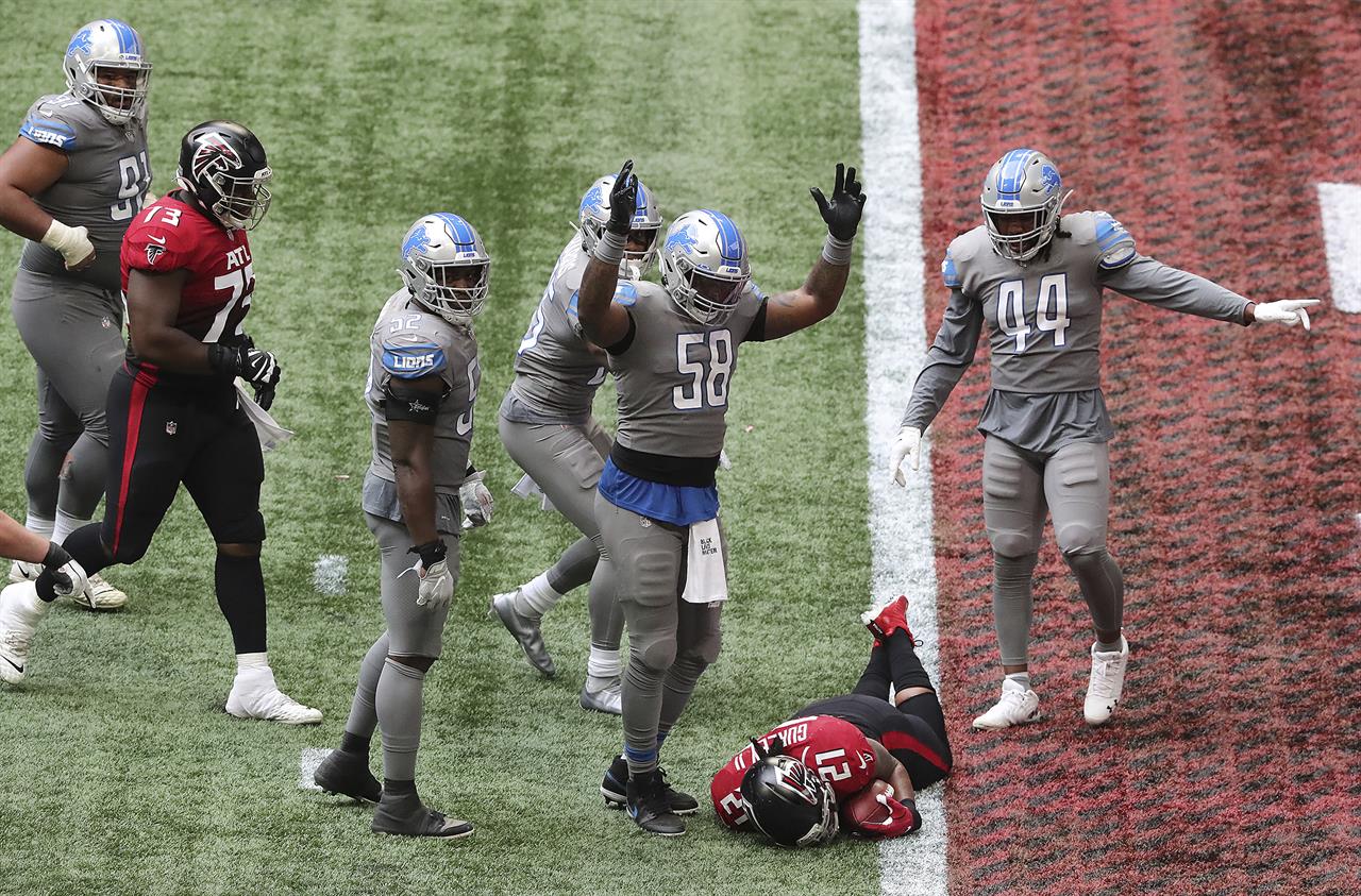 FILE - In this Oct. 25, 2020, file photo, Detroit Lions linebacker Jamie Collins signals touchdown as Atlanta Falcons running back Todd Gurley tries to stop short of the end zone to control the final minutes of the clock in the fourth quarter of an NFL football game in Atlanta. Against a conceding opponent, whose only hope was to take advantage of a ballcarrier's natural inclination to find the end zone, Penn State and the Falcons inadvertently took the bait and ended up losing games they pretty much had wrapped up. (Curtis Compton/Atlanta Journal-Constitution via AP, File)
