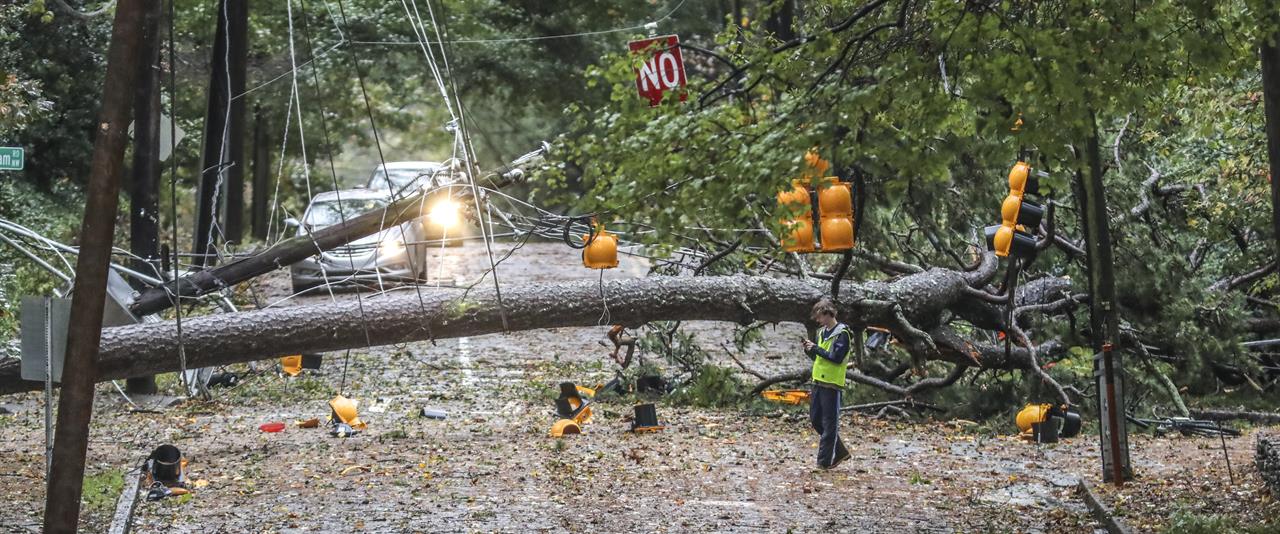 A large tree fell across West Wesley Road and Habersham Road where it remained closed most of the day Thursday, Oct. 29, 2020 in Atlanta. Rain bands and damaging winds from Tropical Storm Zeta swept through North Georgia on Thursday morning, leaving nearly 1 million in the dark. (John Spink/Atlanta Journal-Constitution via AP)