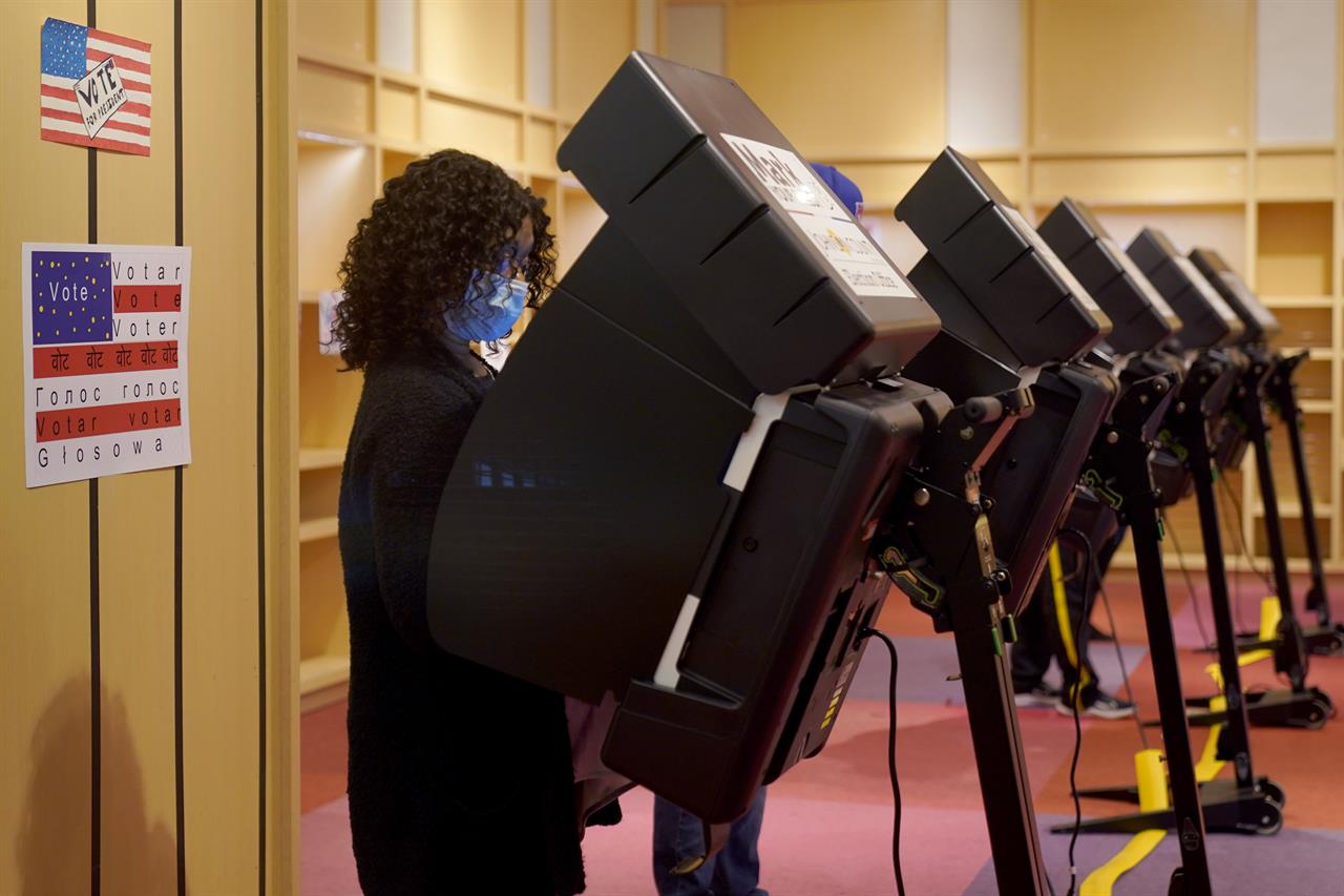 A woman casts her ballot on the first day of early voting in a recently-shuttered store at Oak Park Mall Saturday, Oct. 17, 2020, in Overland Park, Kan. (AP Photo/Charlie Riedel, File)