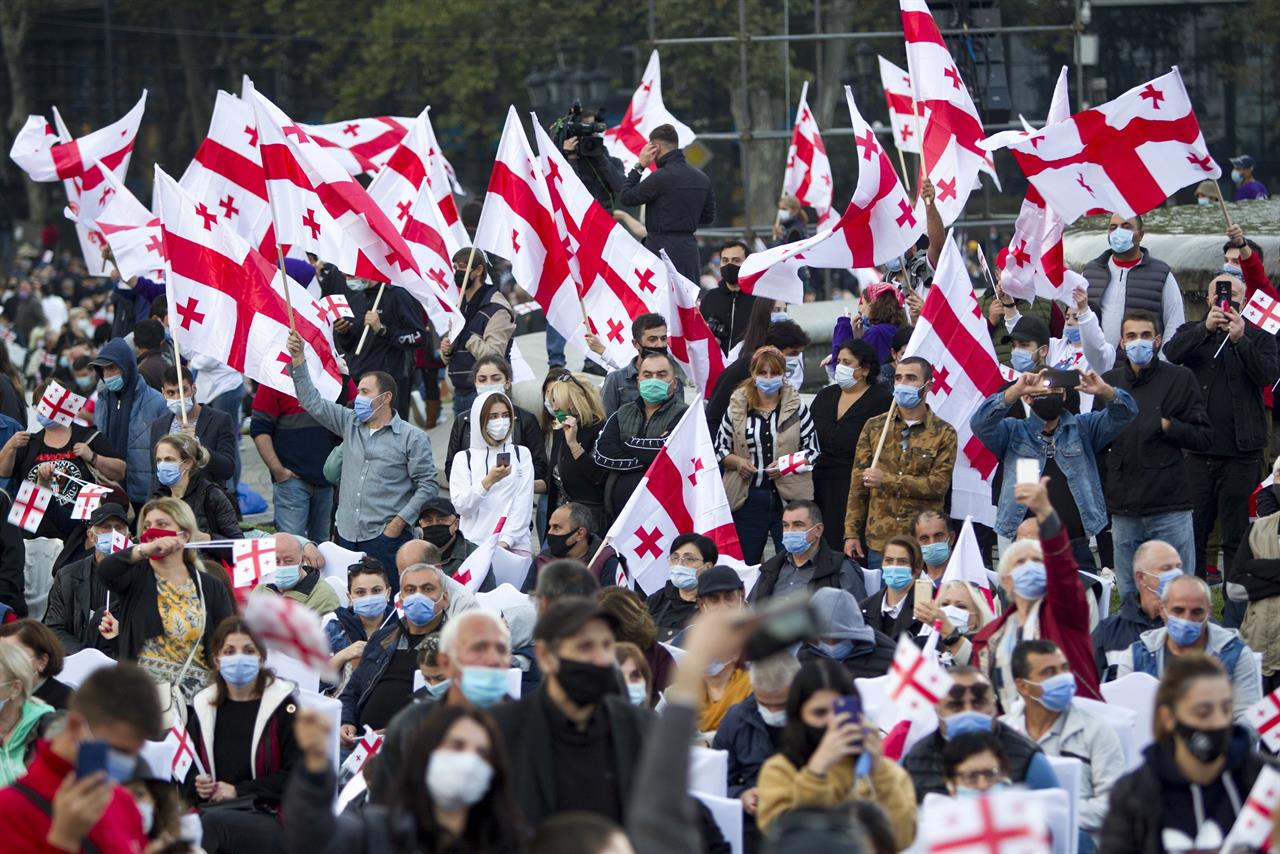 Supporters of the United National Movement party, most of them wearing face masks to help curb the spread of the coronavirus, with Georgian national flags attend a parliamentary election campaign rally in Tbilisi, Georgia, Thursday, Oct. 29, 2020. The parliamentary elections will take place in Georgia on Saturday, Oct. 31, 2020. (AP Photo/Shakh Aivazov)