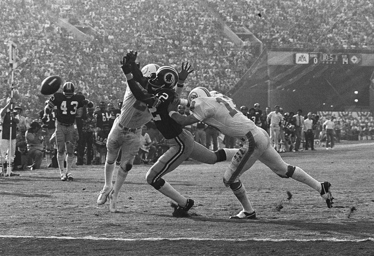 FILE - In this Jan. 14, 1973, file photo, Miami Dolphins' Lloyd Mumphord, left, and Jake Scott (13) break up a pass to Washington Redskins' Charley Taylor near the goal line to stop a Redskins drive during NFL football's Super Bowl 7 in Los Angeles. Scott, the star safety who was the most valuable player in the Super Bowl that completed the Dolphins’ 1972 perfect season, died Thursday, Nov. 19, 2020, in Atlanta. He was 75.
Scott died after a fall down a stairway that left him in a coma, former teammate Dick Anderson said. (AP Photo, File)