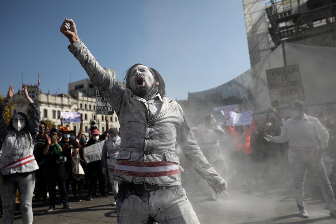 A man dressed as a zombie wears a presidential sash, to represent himself as a minister of Peru's newly sworn-in president, gets revved up in San Martin plaza where people who are refusing to recognize the new government gather to protest in Lima, Peru, Saturday, Nov. 14, 2020. Peru swore in its third president in just over a week Tuesday in a televised ceremony that residents of the fraught South American country watched with both hope and skepticism after the worst constitutional crisis in two decades. (AP Photo/Rodrigo Abd)