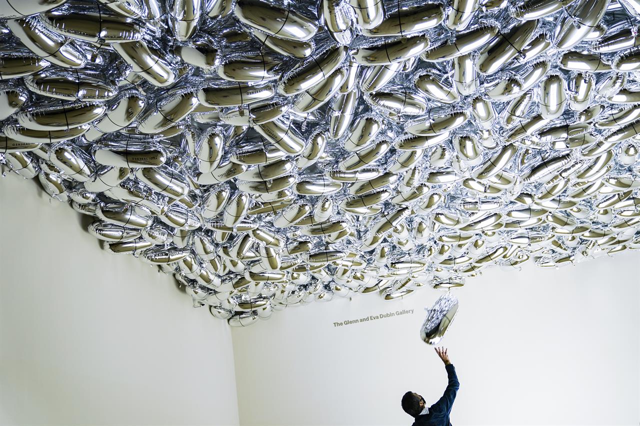 Workers put the finishing installation touches on artist General Idea's "Magic Bullet" at the Museum of Modern Art in the new fall review spaces, Friday, Nov. 13, 2020, in New York. (AP Photo/John Minchillo)