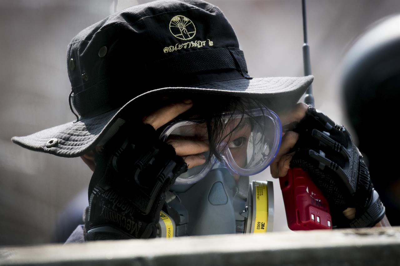 A pro-democracy demonstrator puts on googles during clashes with riot police near the Parliament in Bangkok, Tuesday, Nov. 17, 2020. Thailand's political battleground shifted to the country's Parliament Tuesday, where lawmakers are considering proposals to amend the country's constitution, one of the core demands of the student-led pro-democracy movement. (AP Photo/Wason Wanichakorn)