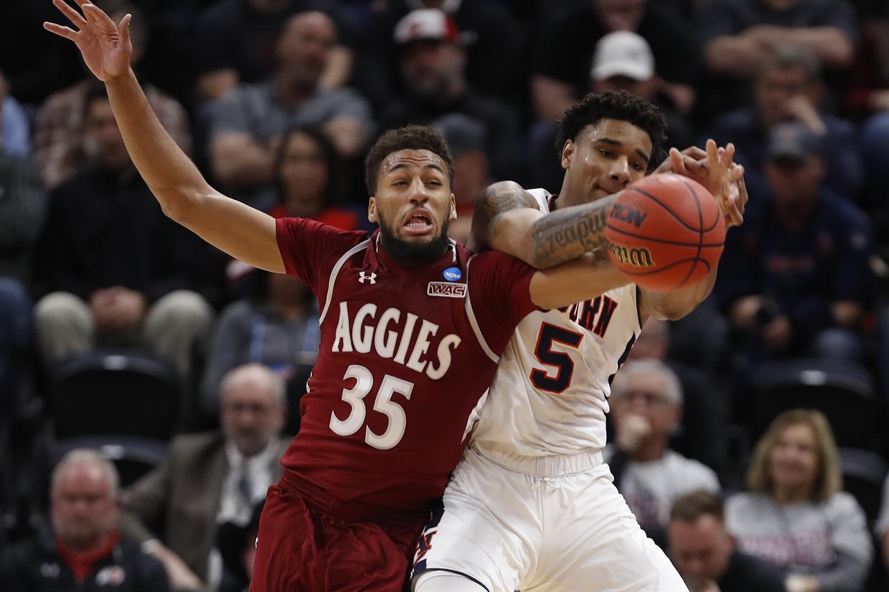 FILE - In this Thursday, March 21, 2019, file photo, New Mexico State forward Johnny McCants (35) and Auburn forward Chuma Okeke (5) battle for the ball in the first half during a first round men's college basketball game in the NCAA Tournament in Salt Lake City. Coronavirus restrictions in New Mexico make it impossible for the schools there to play their seasons. McCants and his New Mexico State teammates have settled into a regular routine less than a week after the team temporarily relocated to Phoenix, amid the pandemic. (AP Photo/Jeff Swinger, File)
