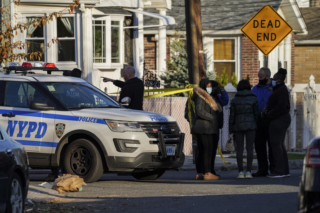 Police maintain a perimeter outside a crime scene, Tuesday, Nov. 24, 2020, in the Queens borough of New York. Two New York City police officers were wounded Tuesday afternoon by a man who opened fire as they arrived for a wellness check at a home with a history of domestic violence, a law enforcement official said. (AP Photo/John Minchillo)