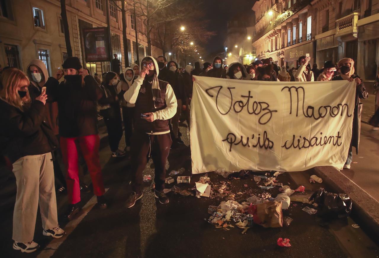 FILE - In this Tuesday, Nov.24, 2020 file photo, demonstrators march with a banner that reads "Vote for Macron they said", during a rally against police brutality on the Place de La Republique in Paris. French President Emmanuel Macron on Friday, Nov. 27 said video images showing police officers beating up a Black man “shame us,” and is condemning violence both by and against the police. Macron asked the government to quickly come up with proposals “to reaffirm the link of confidence that should naturally exist between the French and those who protect them” and to better fight discrimination. (AP Photo/Michel Euler, file)