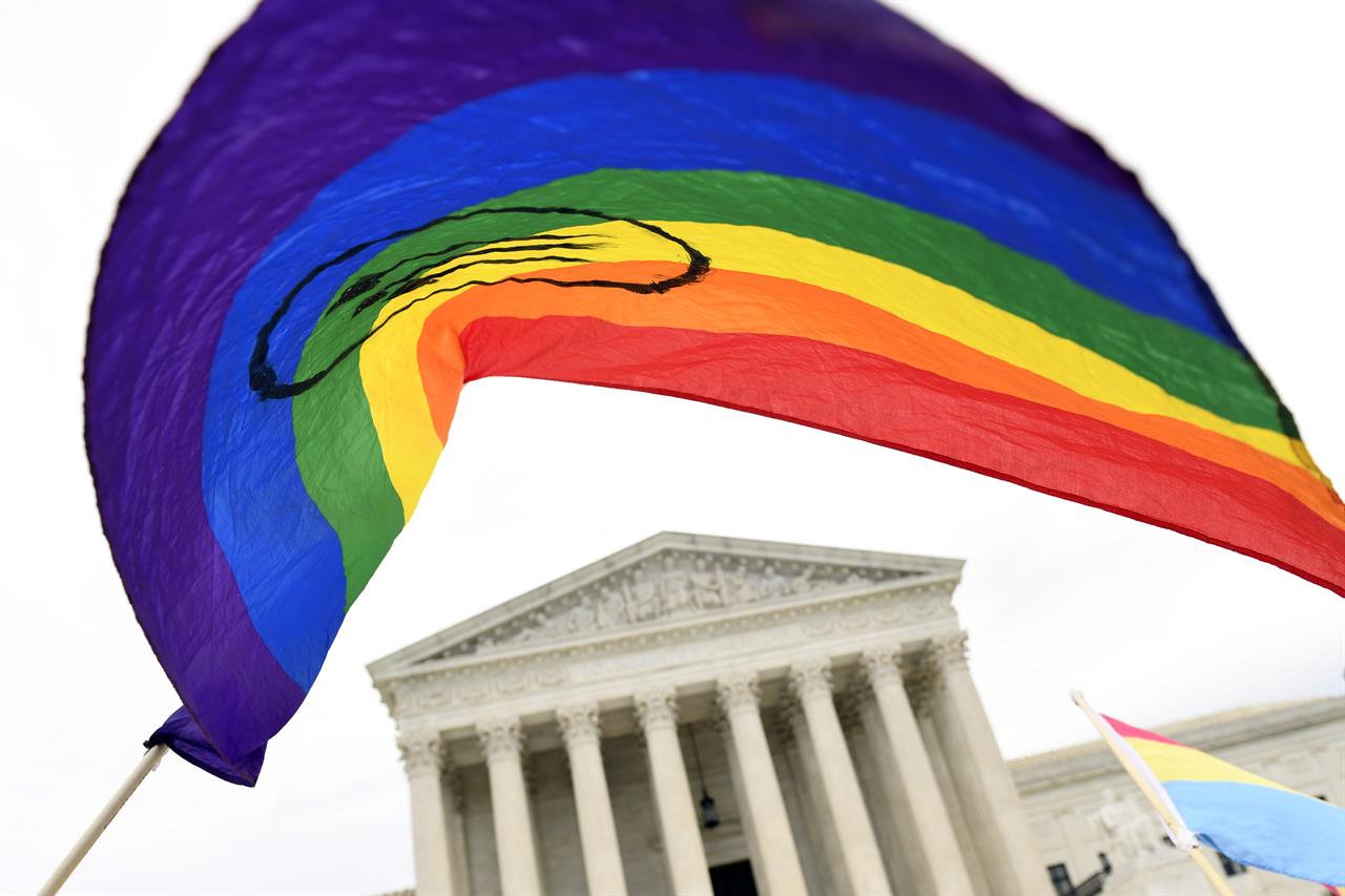 FILE - In this Oct. 8, 2019 file photo, protesters gather outside the Supreme Court in Washington where the Supreme Court is hearing arguments in the first case of LGBT rights since the retirement of Supreme Court Justice Anthony Kennedy. As vice president in 2012, Joe Biden endeared himself to many LGBTQ Americans by endorsing same-sex marriage even before his boss, President Barack Obama. Now, as president-elect, Biden is making sweeping promises to LGBTQ activists, proposing to carry out virtually every major proposal on their wish lists. (AP Photo/Susan Walsh, File)