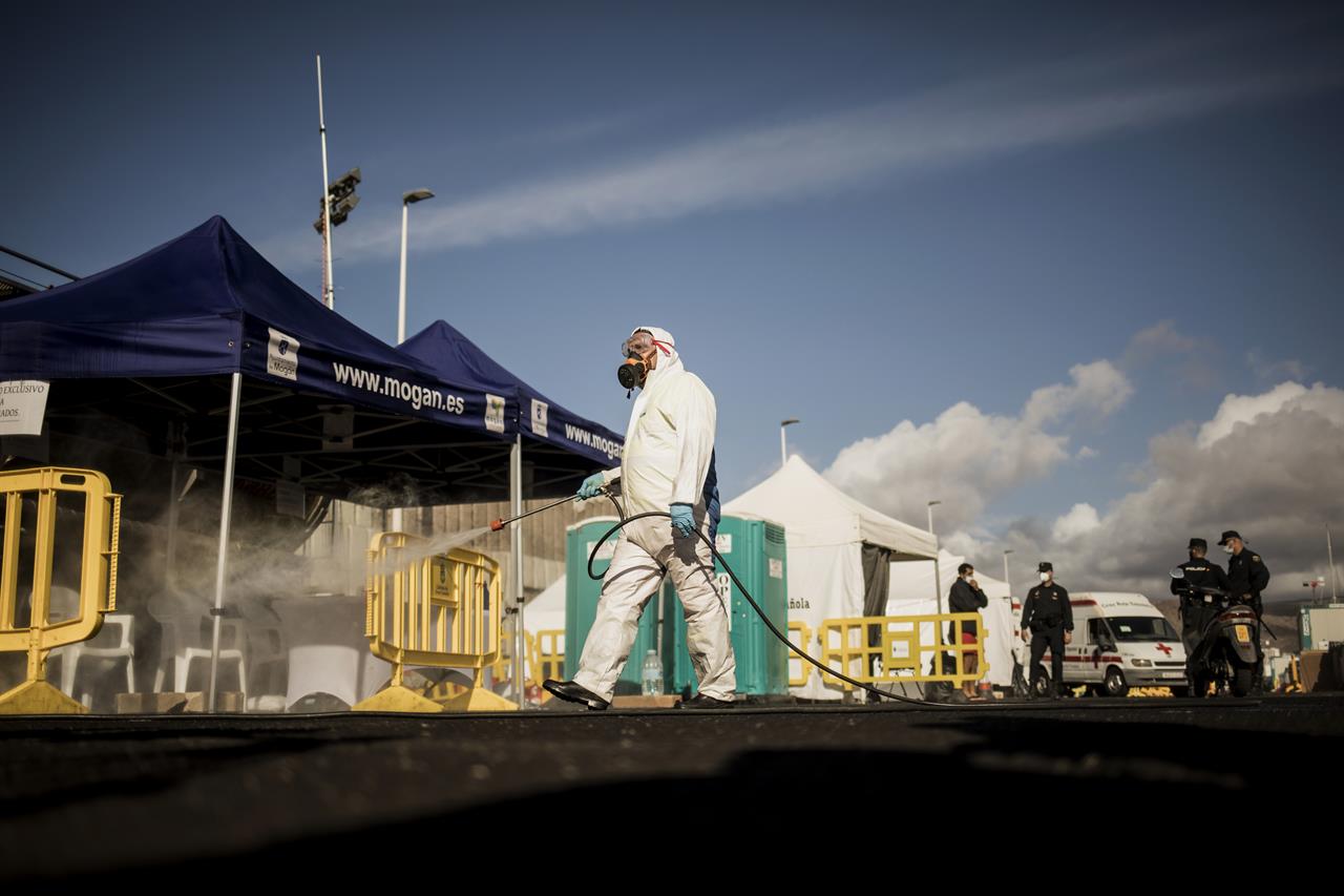 A worker sanitises the area used by migrants at the Arguineguin port, on the southwestern coast of the Gran Canaria island, Spain on Monday Nov. 30, 2020. Spain has dismantled most of the temporary camp for migrant processing that for over three months became known as the "dock of shame" for holding in unfit conditions thousands of Africans arriving lately in the Canary Islands. (AP Photo/Javier Fergo)
