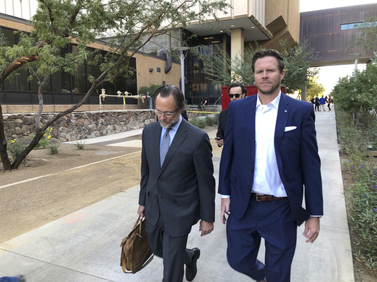 FILE - In this Nov. 5, 2019 file photo, former Maricopa County Assessor Paul Petersen, right, with his attorney, Kurt Altman, leave after a court hearing in Phoenix. Petersen, who admitted running an illegal adoption scheme in three states involving women from the Marshall Islands, was sentenced in Arkansas to six years in federal prison on Tuesday, Dec. 1, 2020. It was the first of three punishments he’ll face for arranging adoptions prohibited by an international compact. (AP Photo/Jacques Billeaud, File)