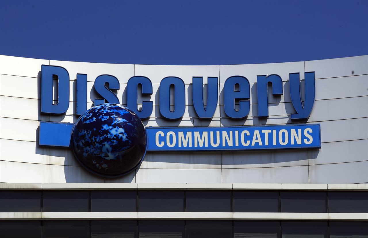 FILE - In this July 31, 2017, file photo, the Discovery Communications logo sits atop its headquarters in Silver Spring, Md. Discovery is joining the increasingly crowded streaming fray with its own reality-focused service Discovery Plus that will include shows from the Food Network, HGTV, TLC and its other networks. It launches Jan 4. (AP Photo/Manuel Balce Ceneta, File)