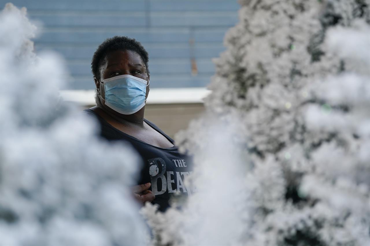 Shannon McNaney wears a mask while shopping for a Christmas tree on Tuesday, Dec. 1, 2020, in Long Beach, Calif. (AP Photo/Ashley Landis)