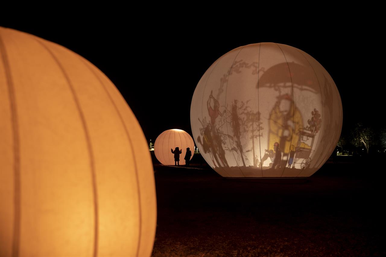 Two children stand in front of a light installations called Moongarden at the Stavros Niarchos Foundation Cultural Center, in Athens, on Wednesday, Dec. 2, 2020. Greece is on lockdown through Dec. 7 but government officials say it is too early to say when schools and businesses will reopen due to continued pressure on the state-run health service, with intensive care wards near capacity in parts of the country. (AP Photo/Petros Giannakouris)