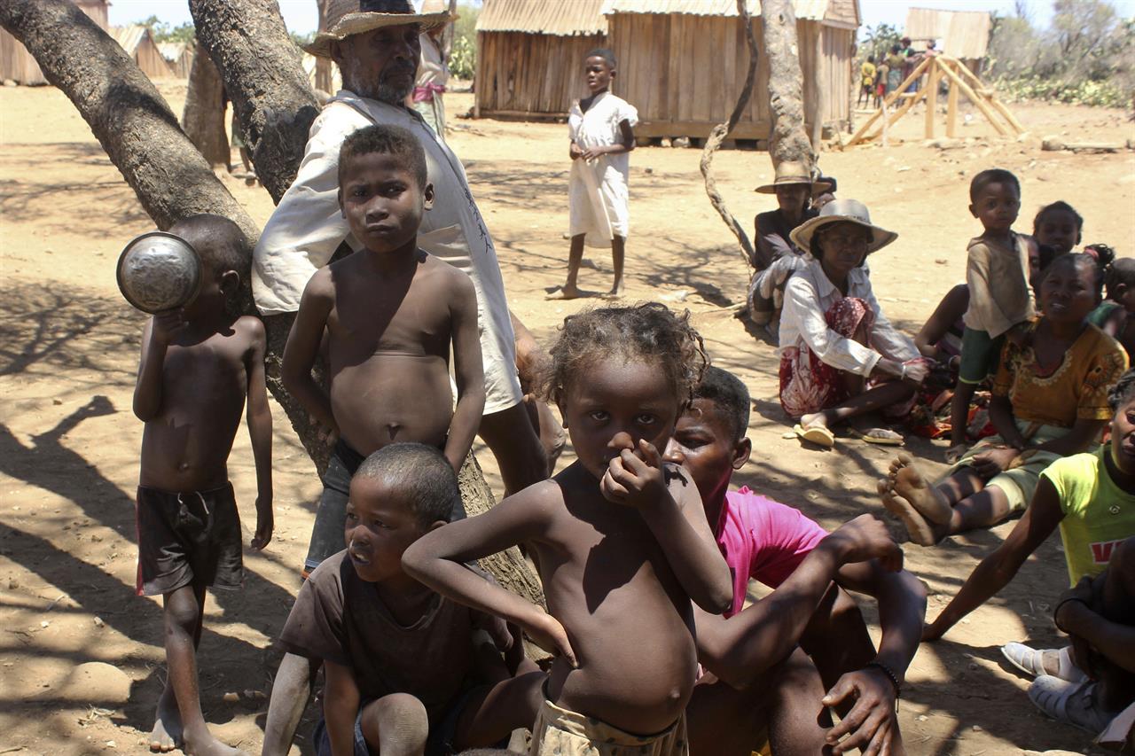 Children shelter from the sun in Ankilimarovahatsy, Madagascar, a village in the far south of the island where most children are acutely malnourished, Monday, Nov. 9, 2020. As a consequence of three straight years of drought, along with historic neglect by the government of the remote region as well as the COVID-19 pandemic,1.5 million people are in need of emergency food assistance, according to the U.N. World Food Program. (AP Photo/Laetitia Began)
