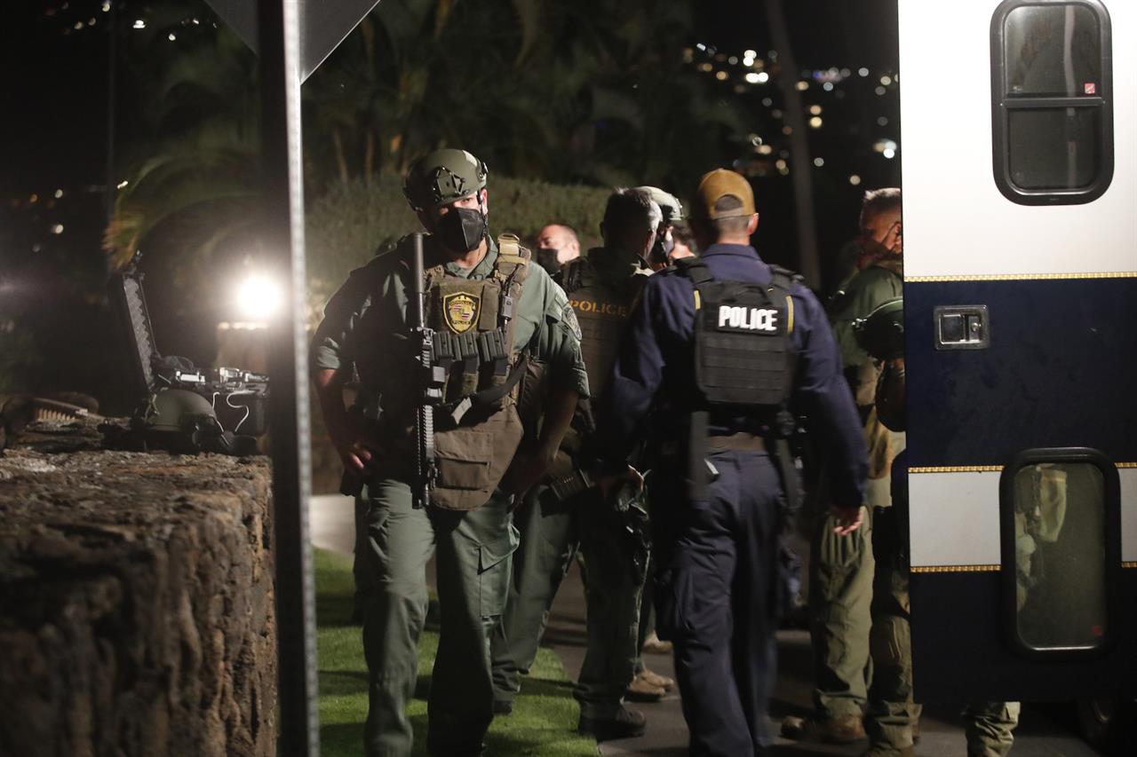 Members of the Honolulu Police Specialized Services Division respond to a barricade situation with an armed man at the Kahala Hotel in Honolulu on Saturday, April 10, 2021. The armed man barricaded himself inside a hotel room at the resort in Honolulu and fired shots through the door, a police official said. (Cindy Ellen Russell/Honolulu Star-Advertiser via AP)