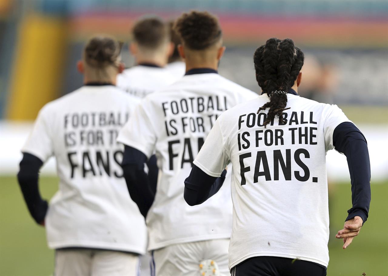 Leeds United players wear t-shirts with the logo 'Football Is For The Fans' as they warm-up ahead of ahead of the English Premier League soccer match between Leeds United and Liverpool at the Elland Road stadium in Leeds, England, Monday, April 19, 2021. (Clive Brunskill/Pool via AP)